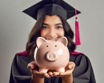 A piggy bank in a graduate girl's hand