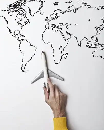 A hand with airplane on outlined world map