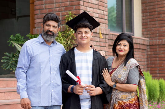 Parents with Happy Indian university boy student and proud parents celebrating graduation degree convocation ceremony